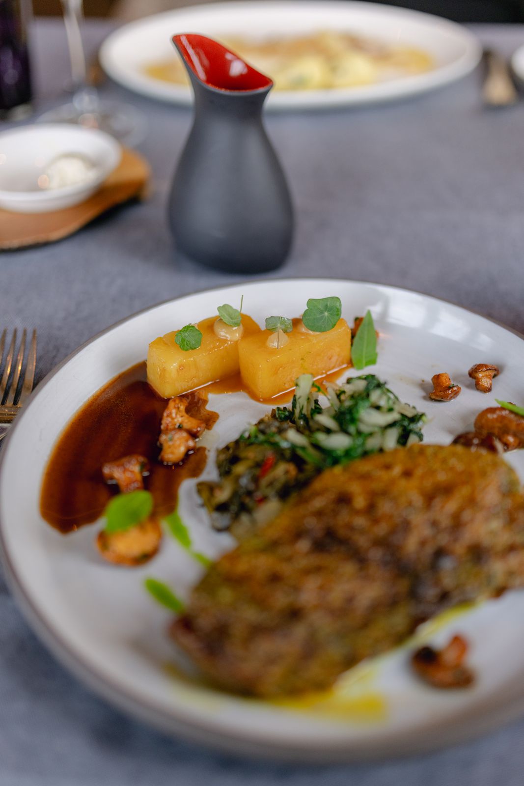 Een zorgvuldig opgemaakt fine-dininggerecht met geroosterde groenten en kruidengarnering