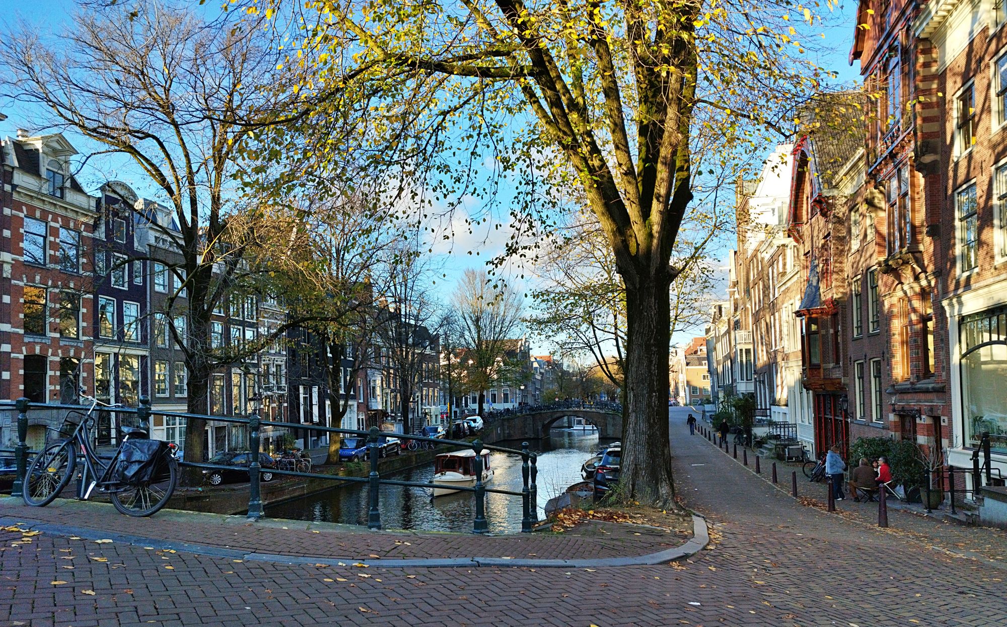 Amsterdam canal with brick gable houses, bare trees and a parked bicycle