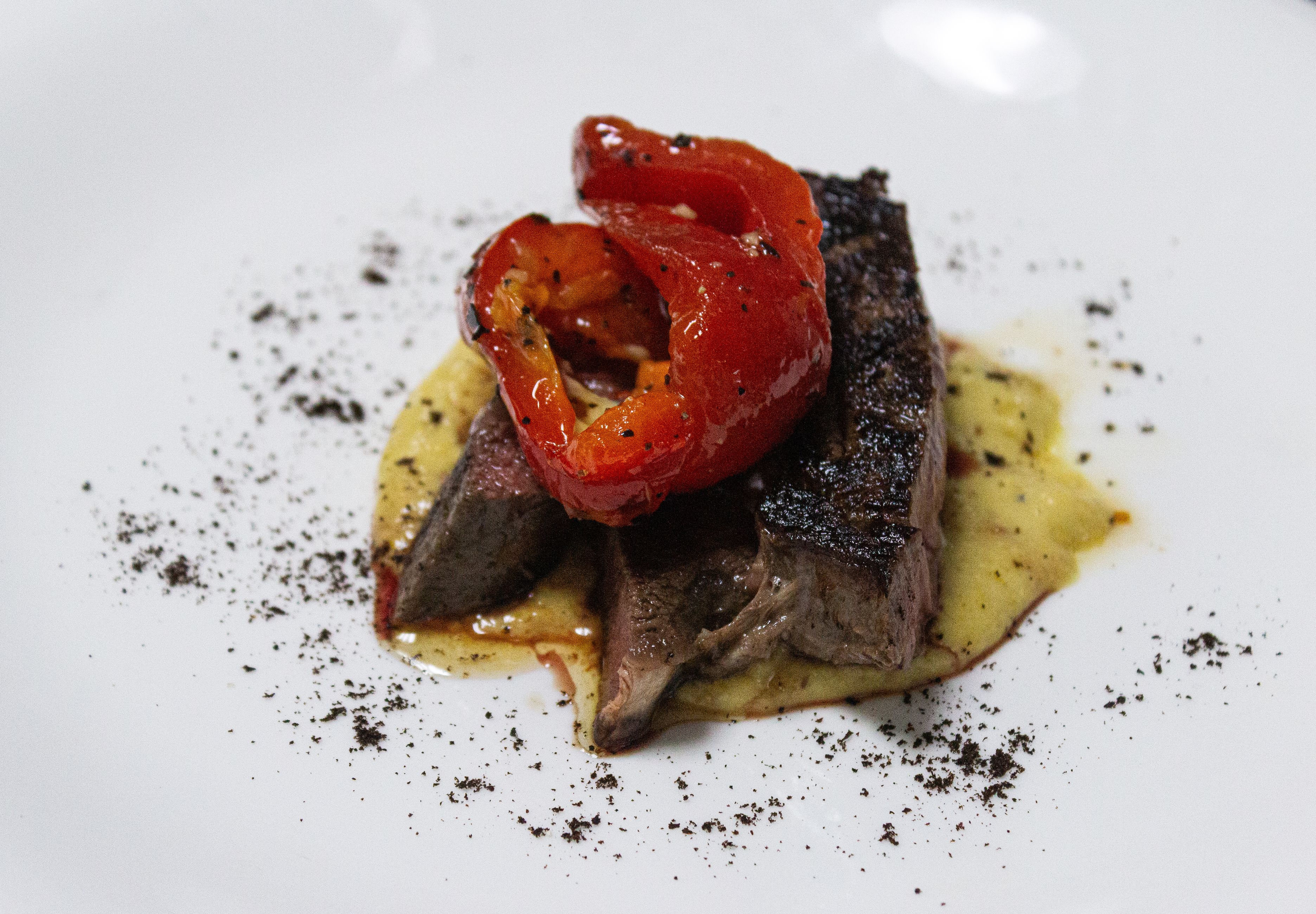Wagyu-style steak plated with roasted red pepper and cream sauce