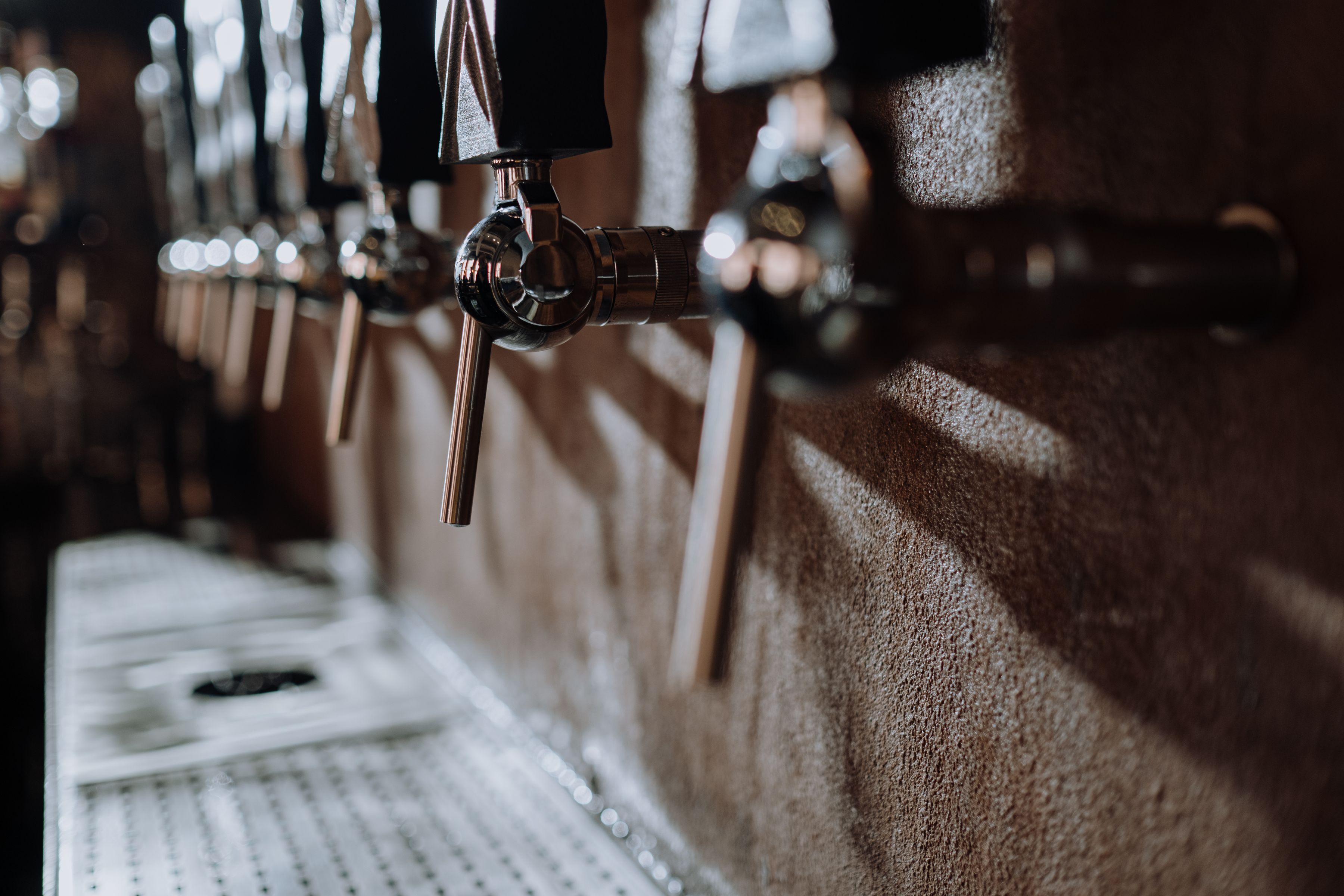 Rij chromen bierkranen langs de bar van een ambachtelijke brouwerij