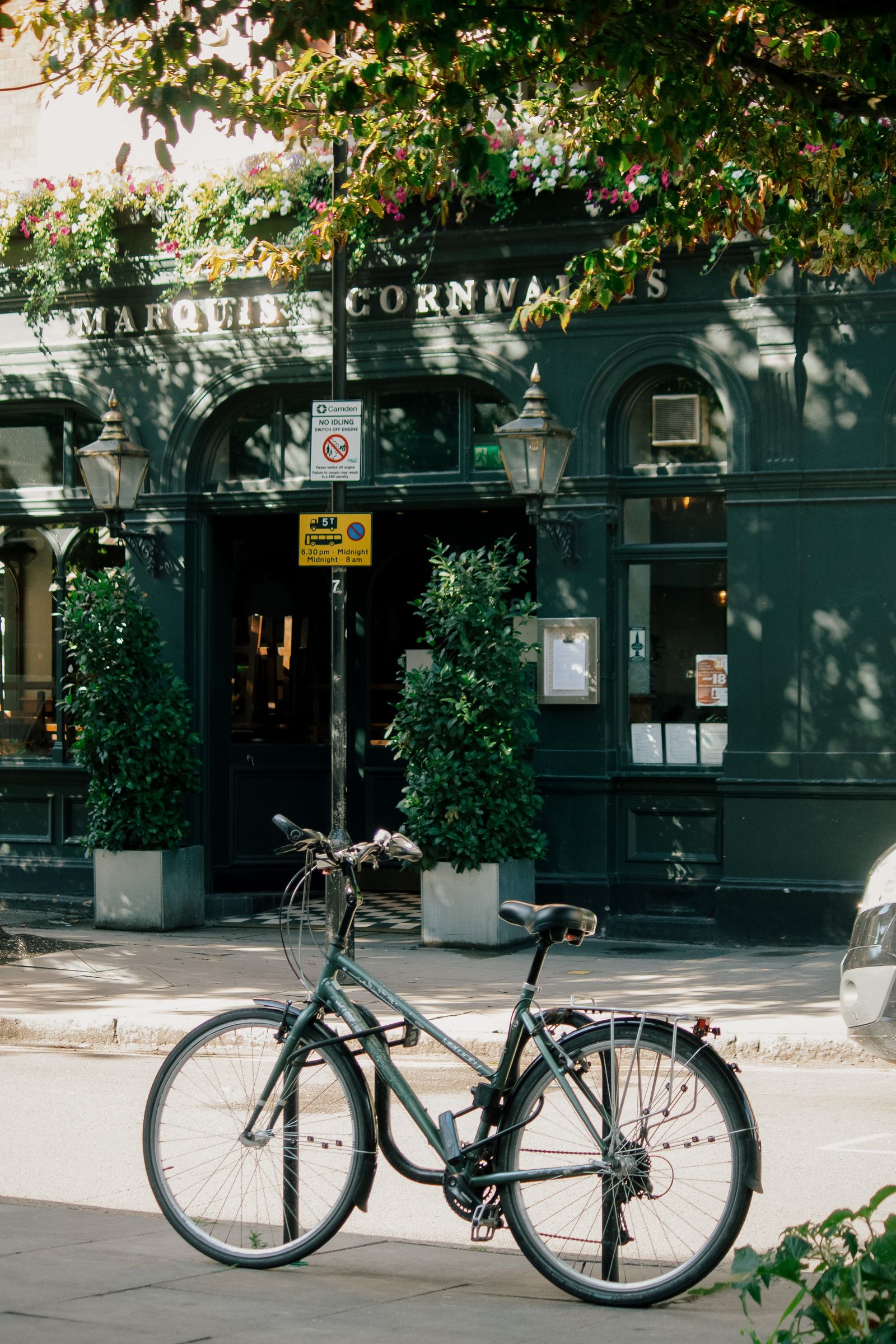 Green-tiled facade of a traditional British pub restaurant on a street