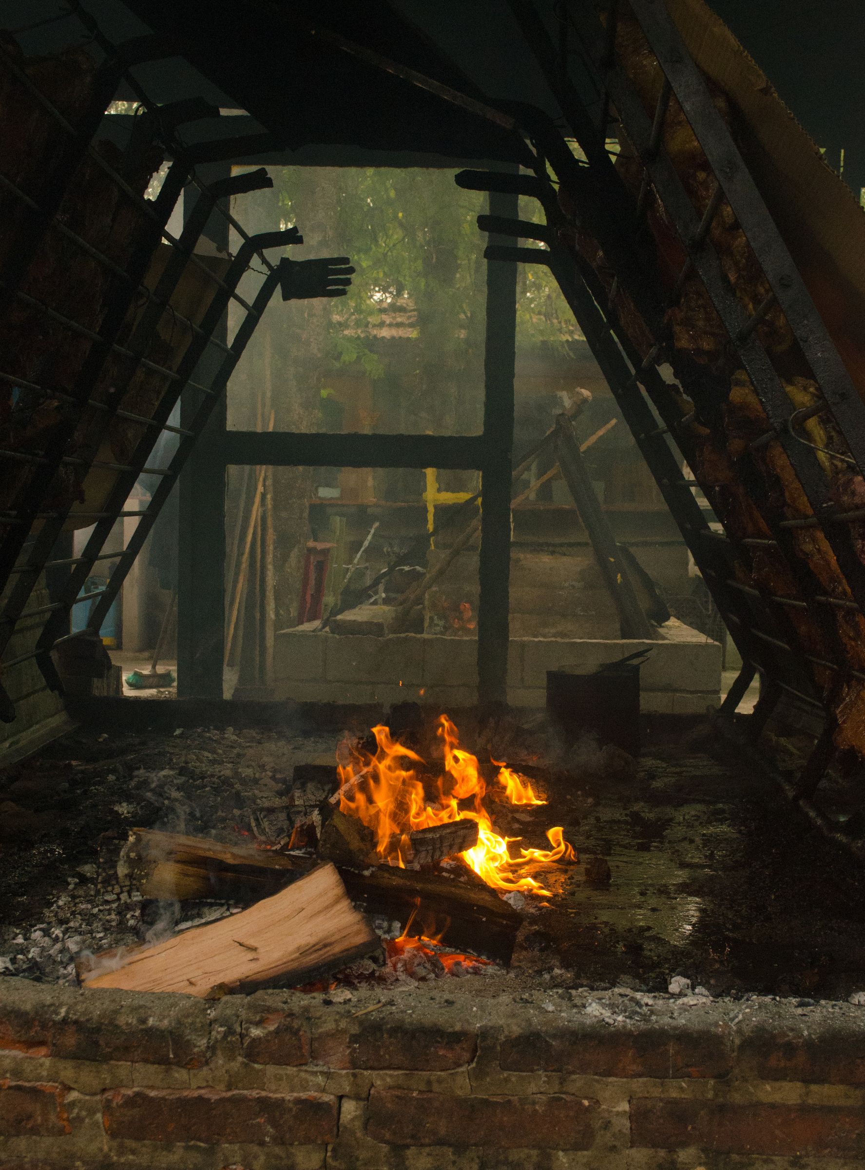 An open wood fire grilling meat in the Argentine asado style