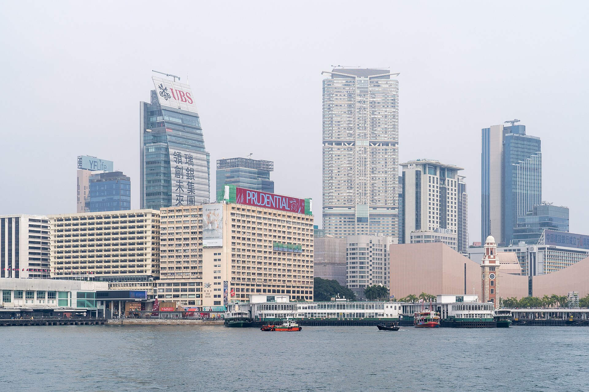 Türme und der Fährpier von Tsim Sha Tsui vom Victoria Harbour aus an einem diesigen Tag