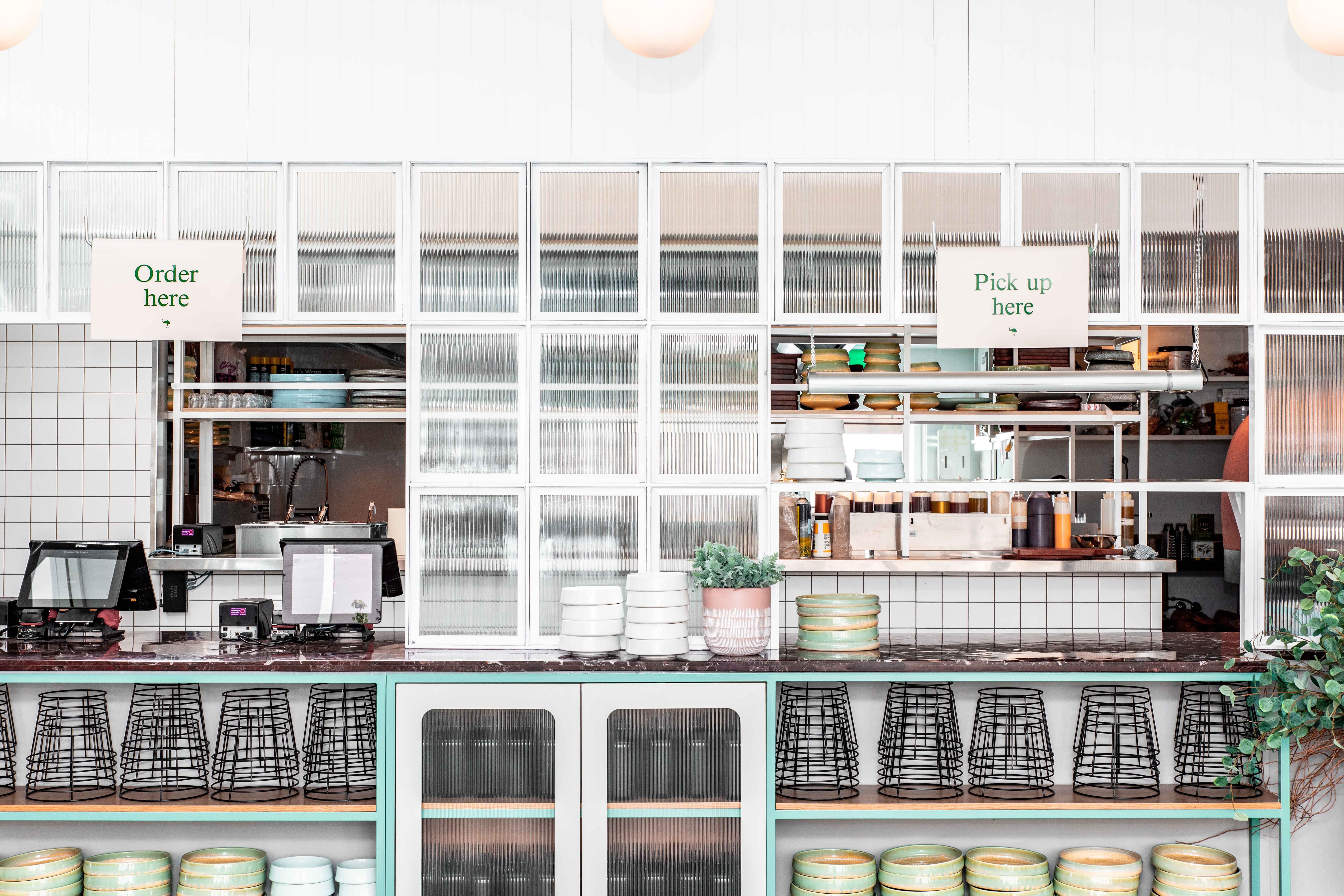Restaurant service counter with stacked crockery and pick-up signs