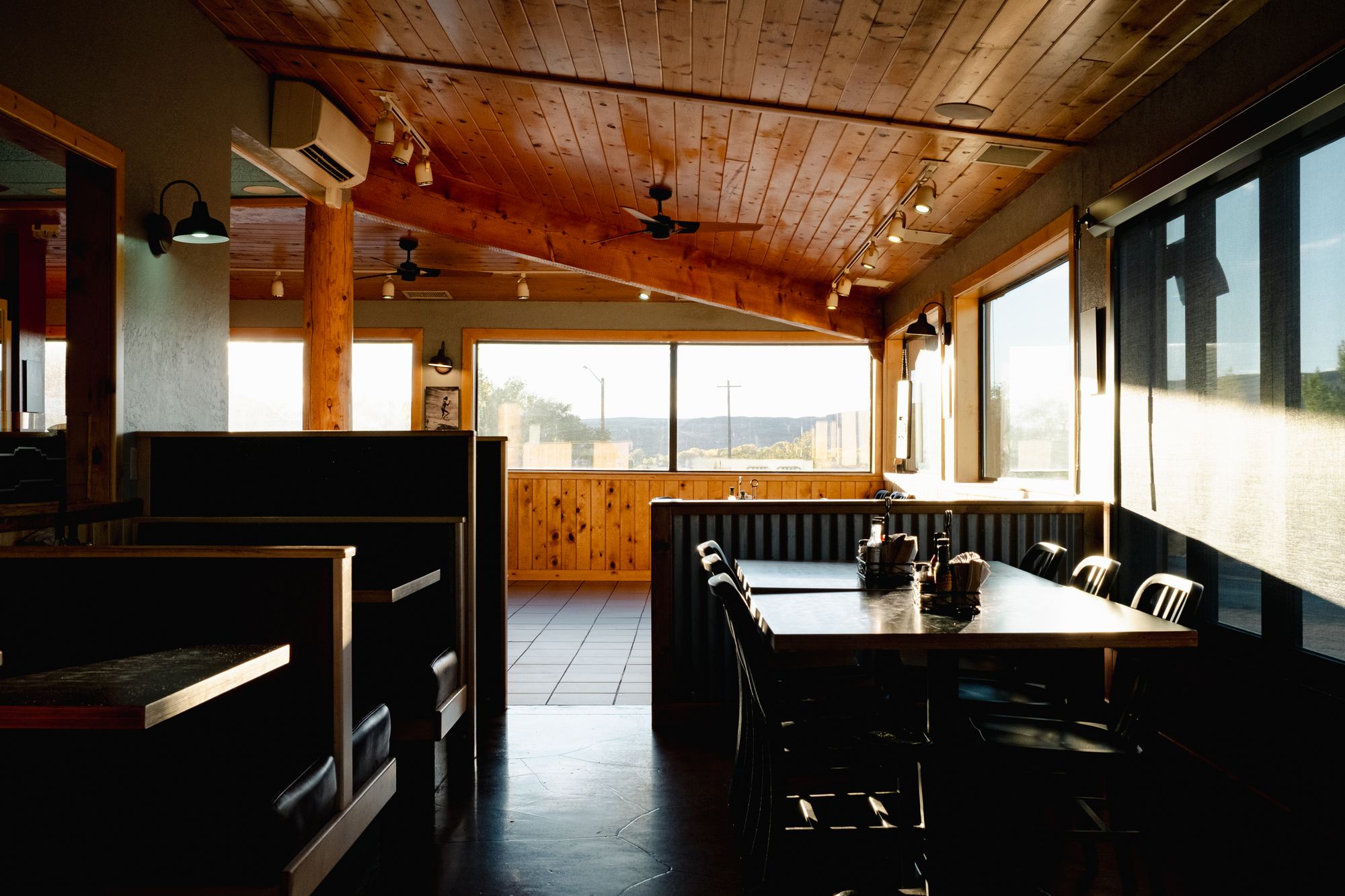 Empty booths and a long table in an American roadside diner at the end of the day