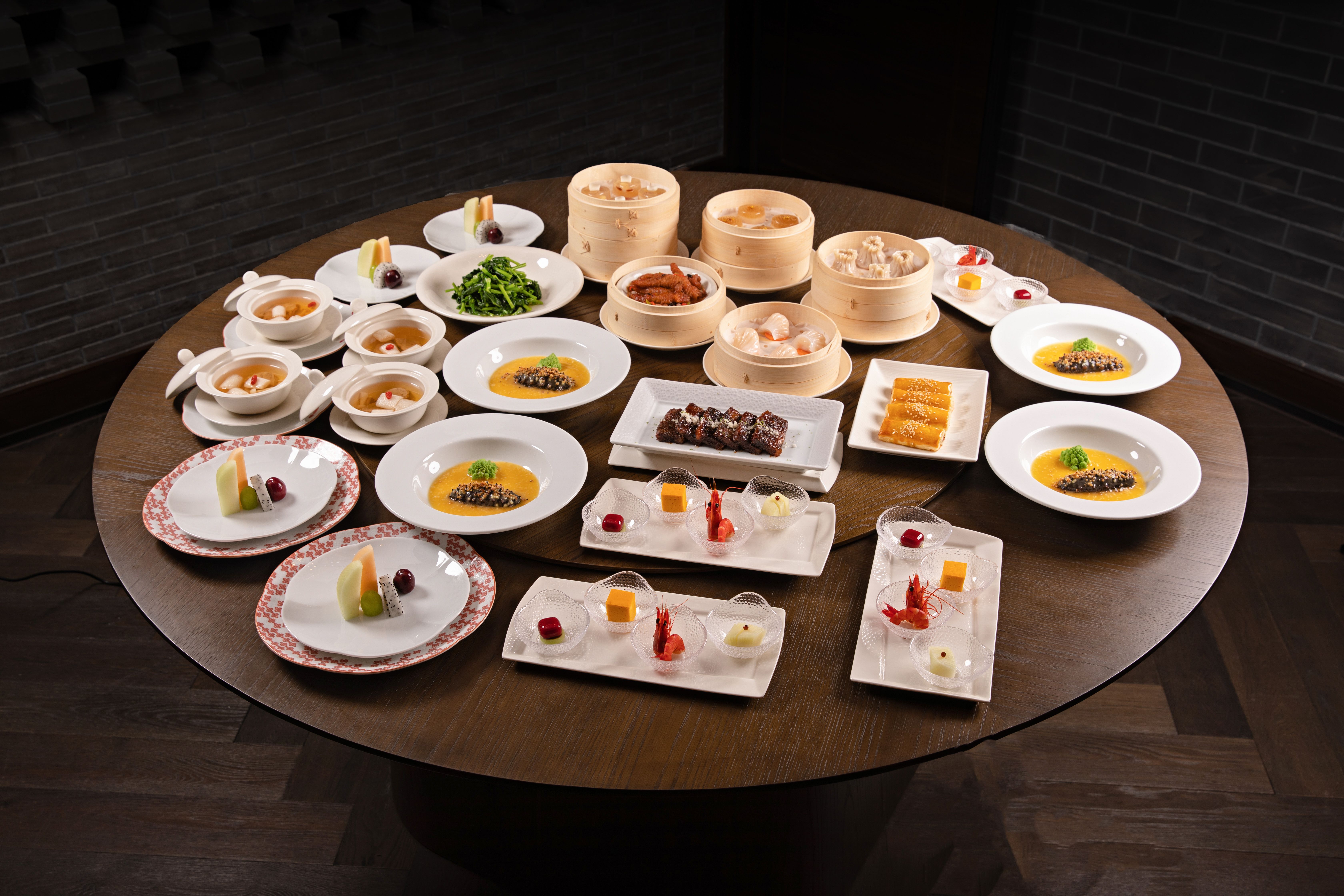 A Chinese tasting menu laid out on a round table with dim sum baskets