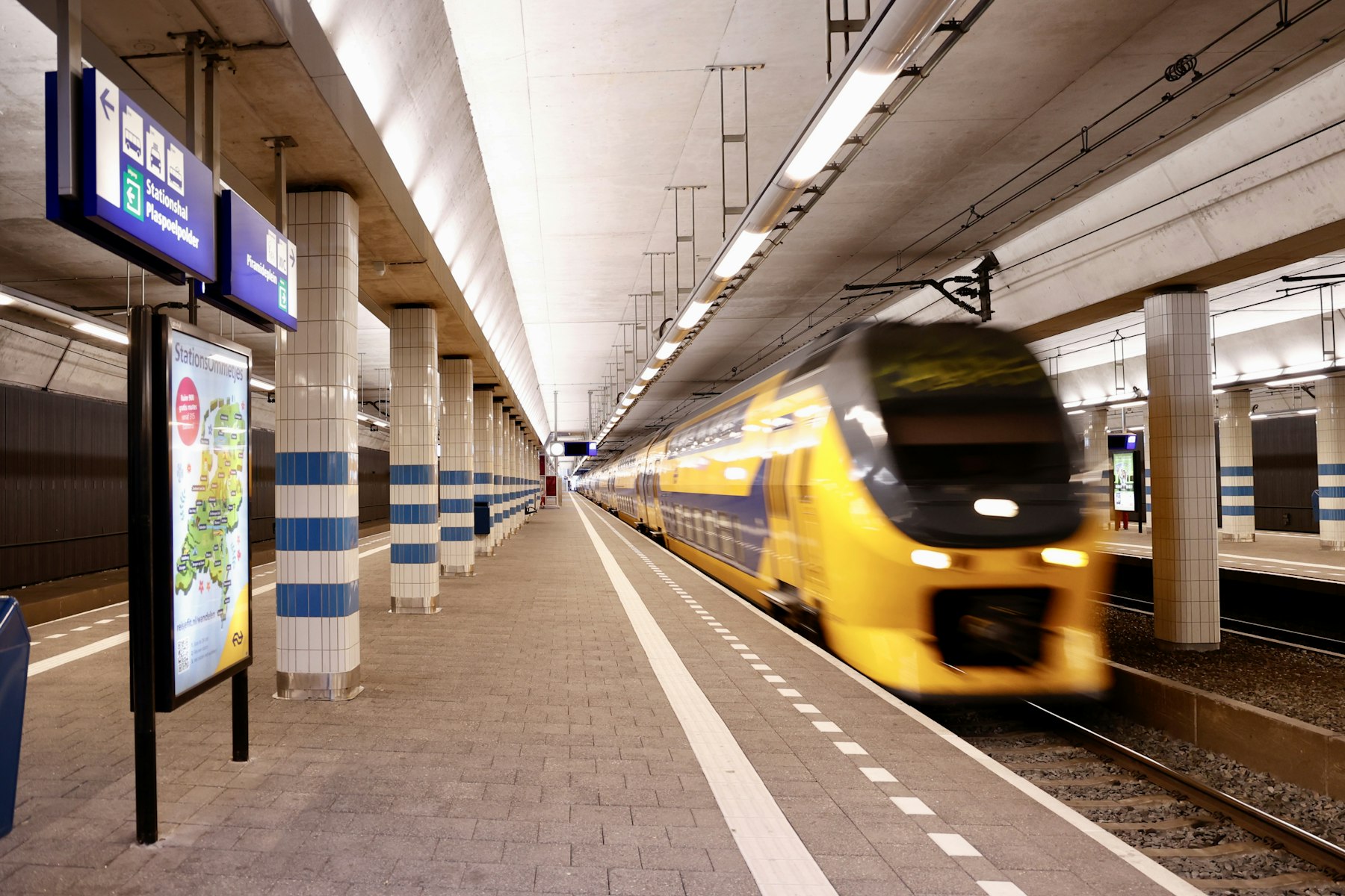 Un treno intercity olandese giallo e blu in arrivo su un binario