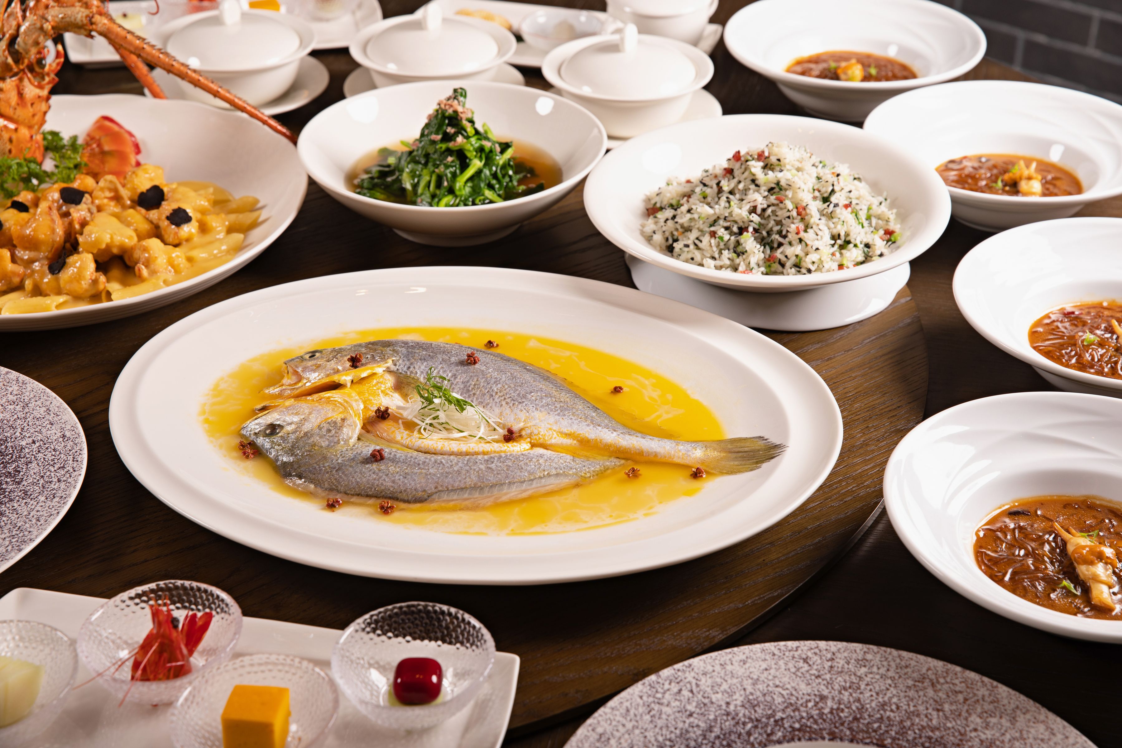Elegant Chinese seafood banquet with steamed fish and rice dishes on a table