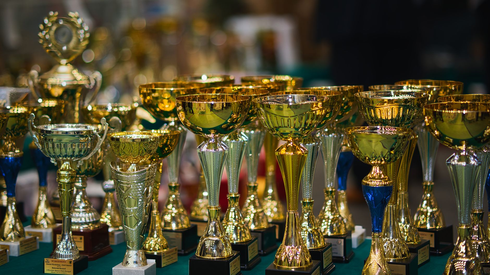 Rangées de coupes trophées dorées et argentées alignées sur une table lors d'une remise de prix