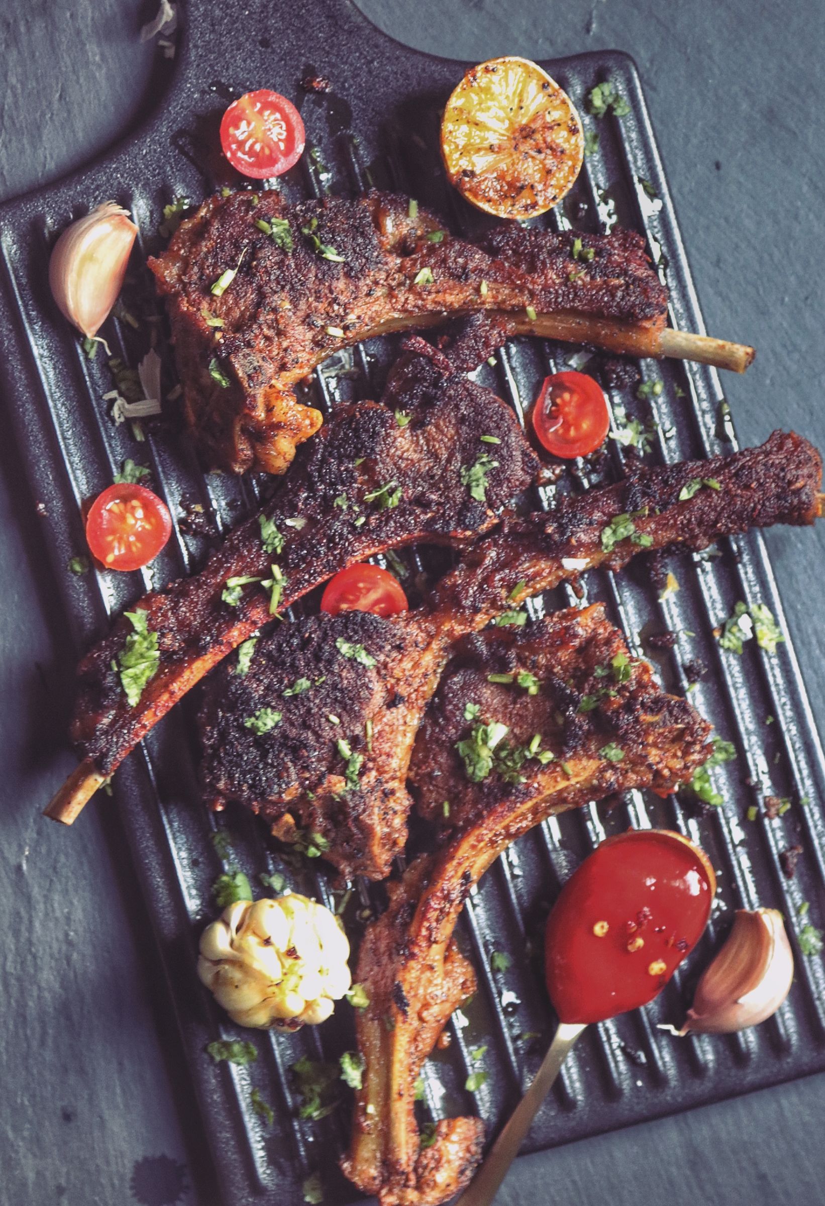 Costolette di agnello grigliate con harissa su una griglia con limone e aglio