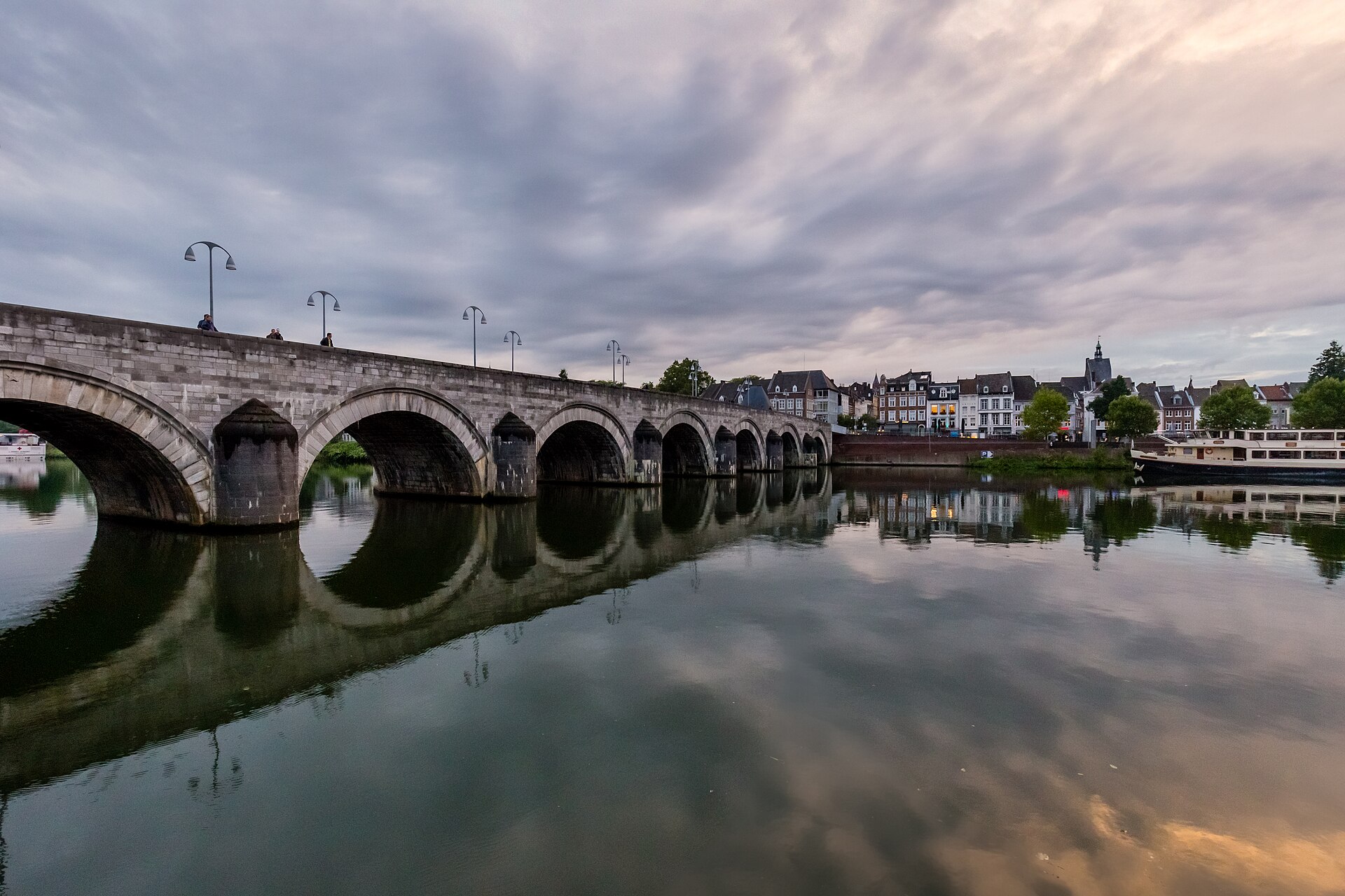 Arcos de piedra del puente de San Servacio reflejados en el Mosa, en Maastricht