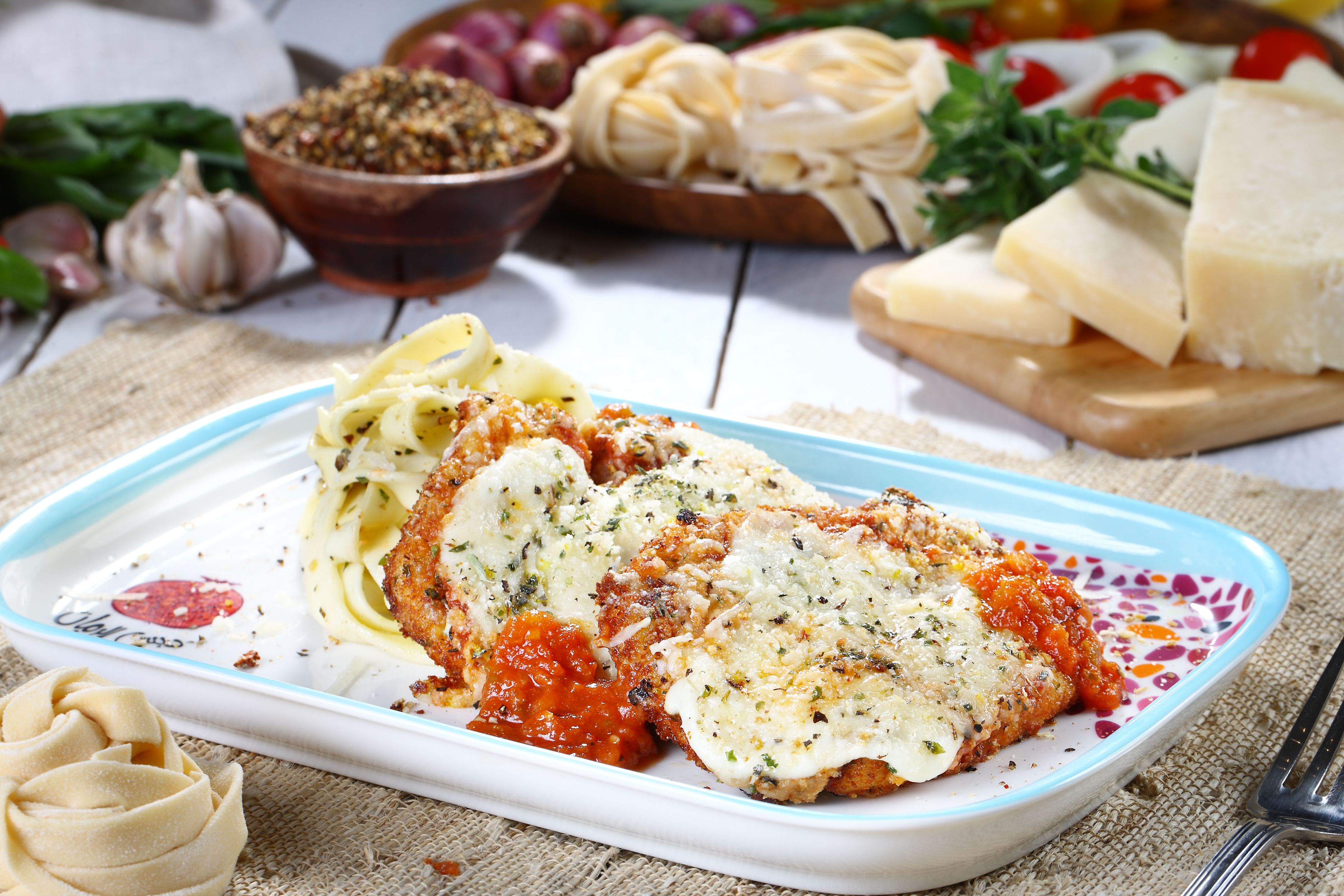 Breaded chicken cutlets topped with melted cheese and tomato sauce, served with pasta