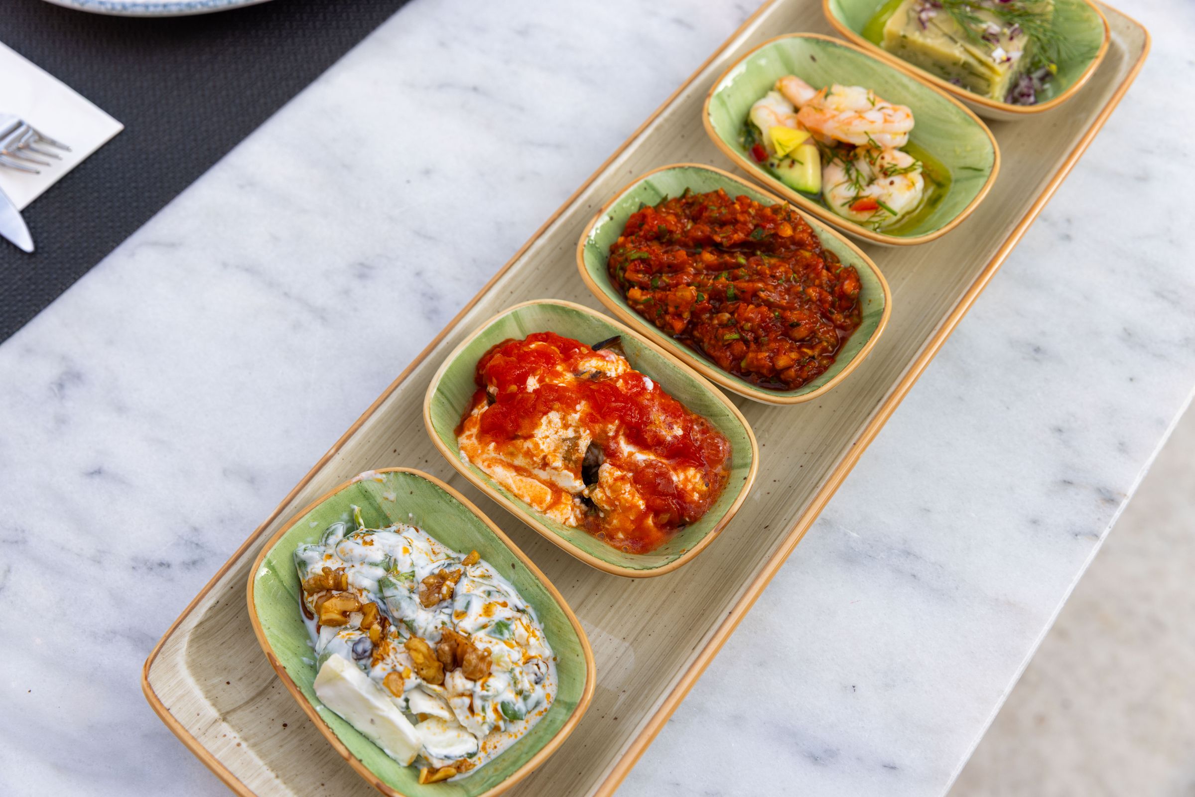 Eine Auswahl kleiner mediterraner Mezze-Gerichte auf einem Marmortisch