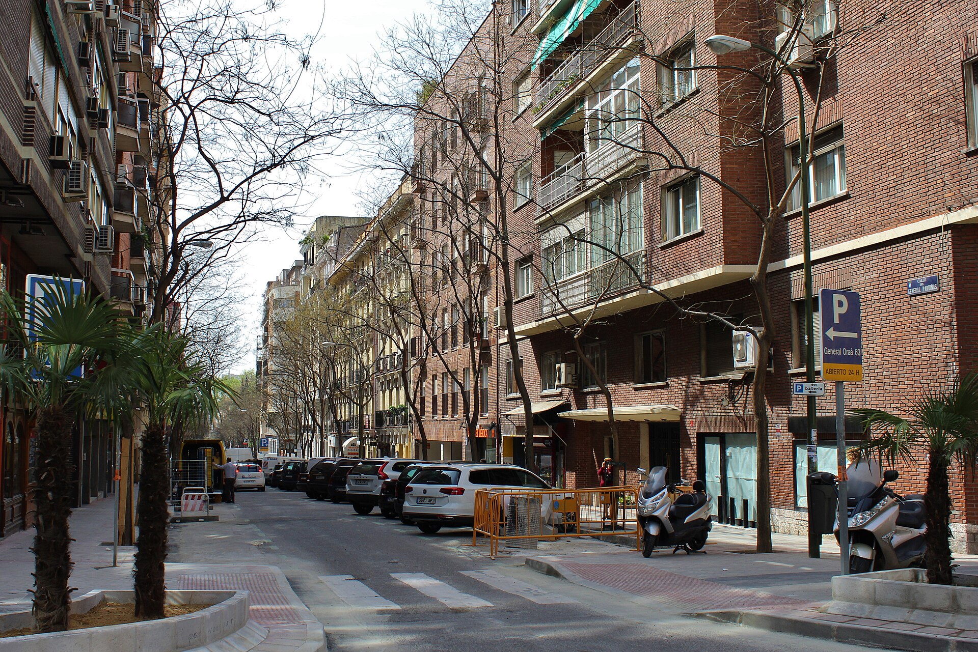Tree-lined Calle del General Pardiñas in Madrid's Salamanca district with parked cars and brick buildings