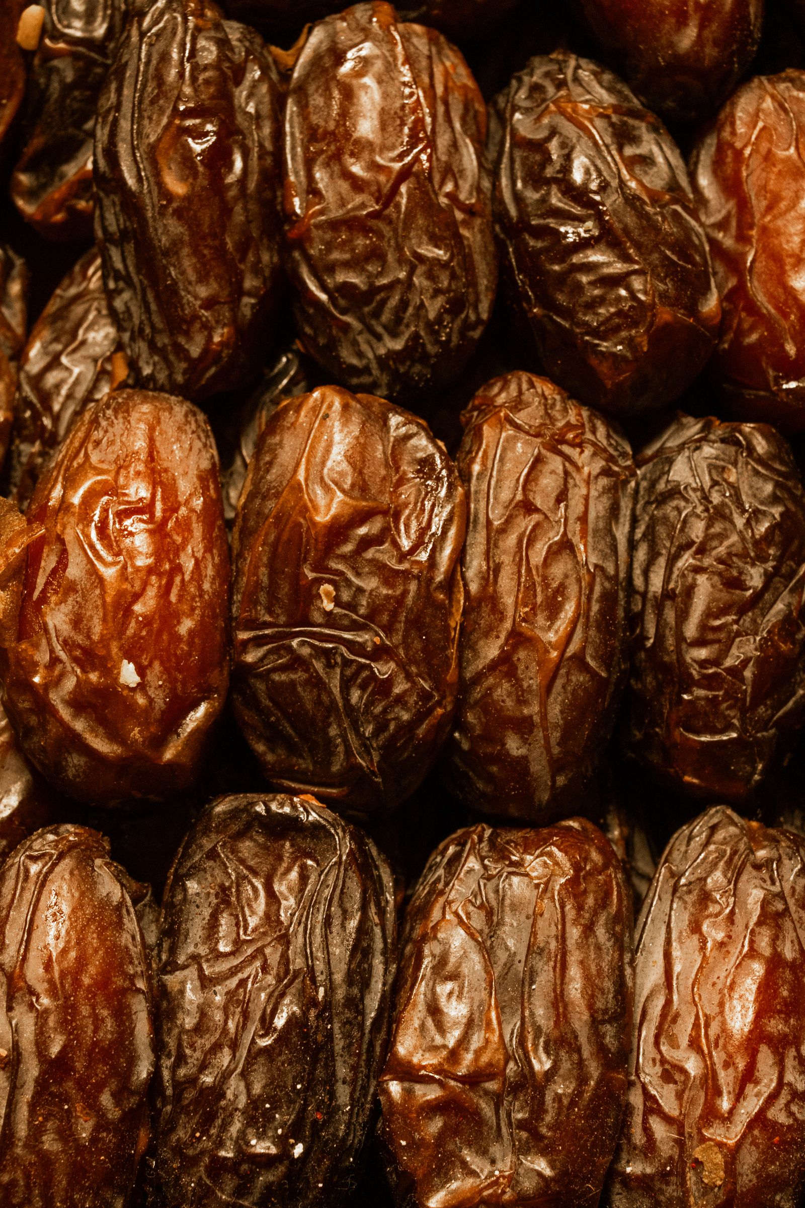A close-up cluster of fresh brown dates still on the palm