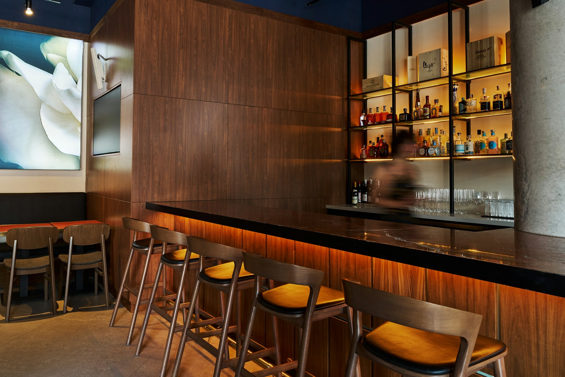 Lege houten restaurantbar met krukken en een verlichte drankenwand