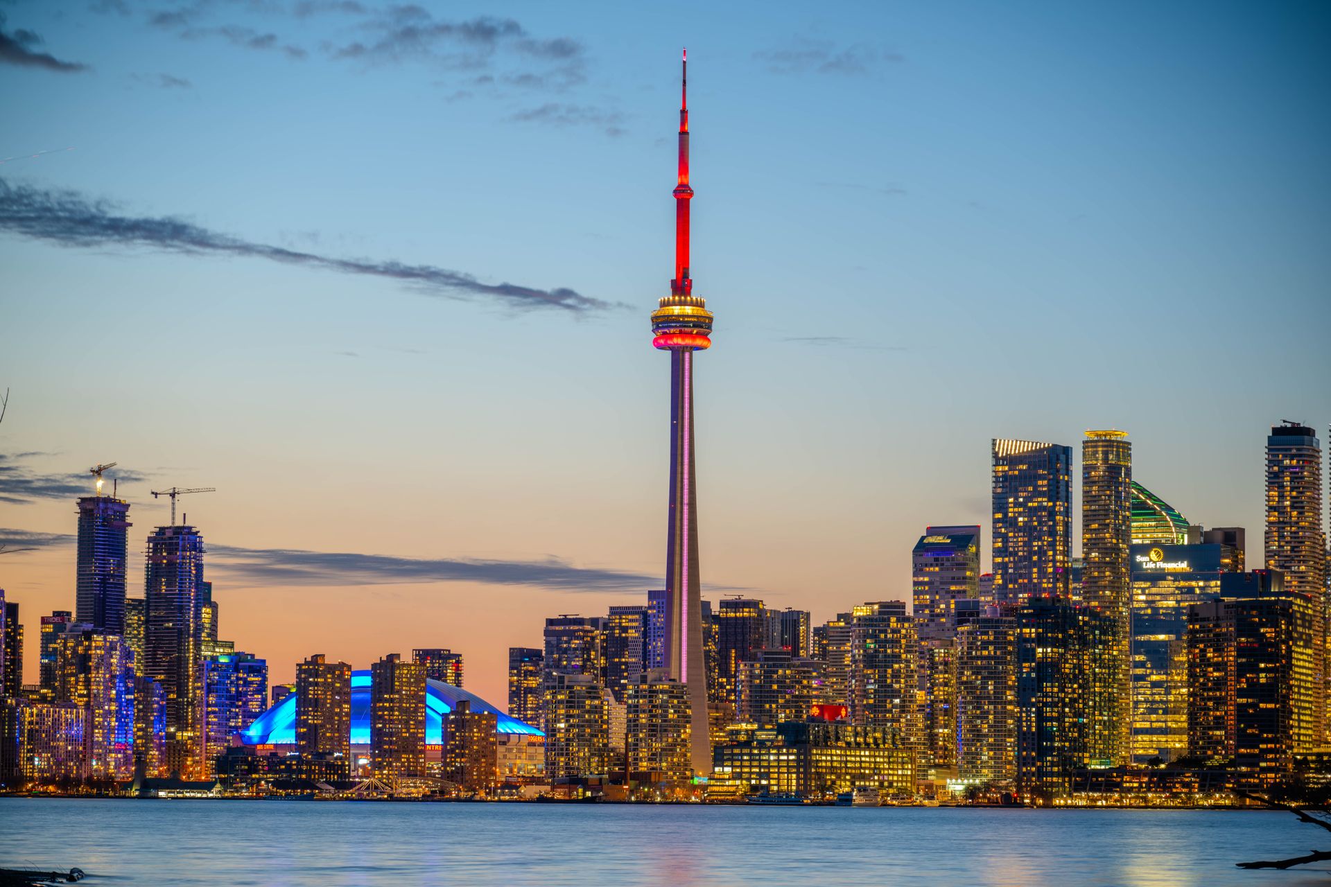 La silhouette de Toronto et la tour CN illuminées au crépuscule, vues depuis l'eau