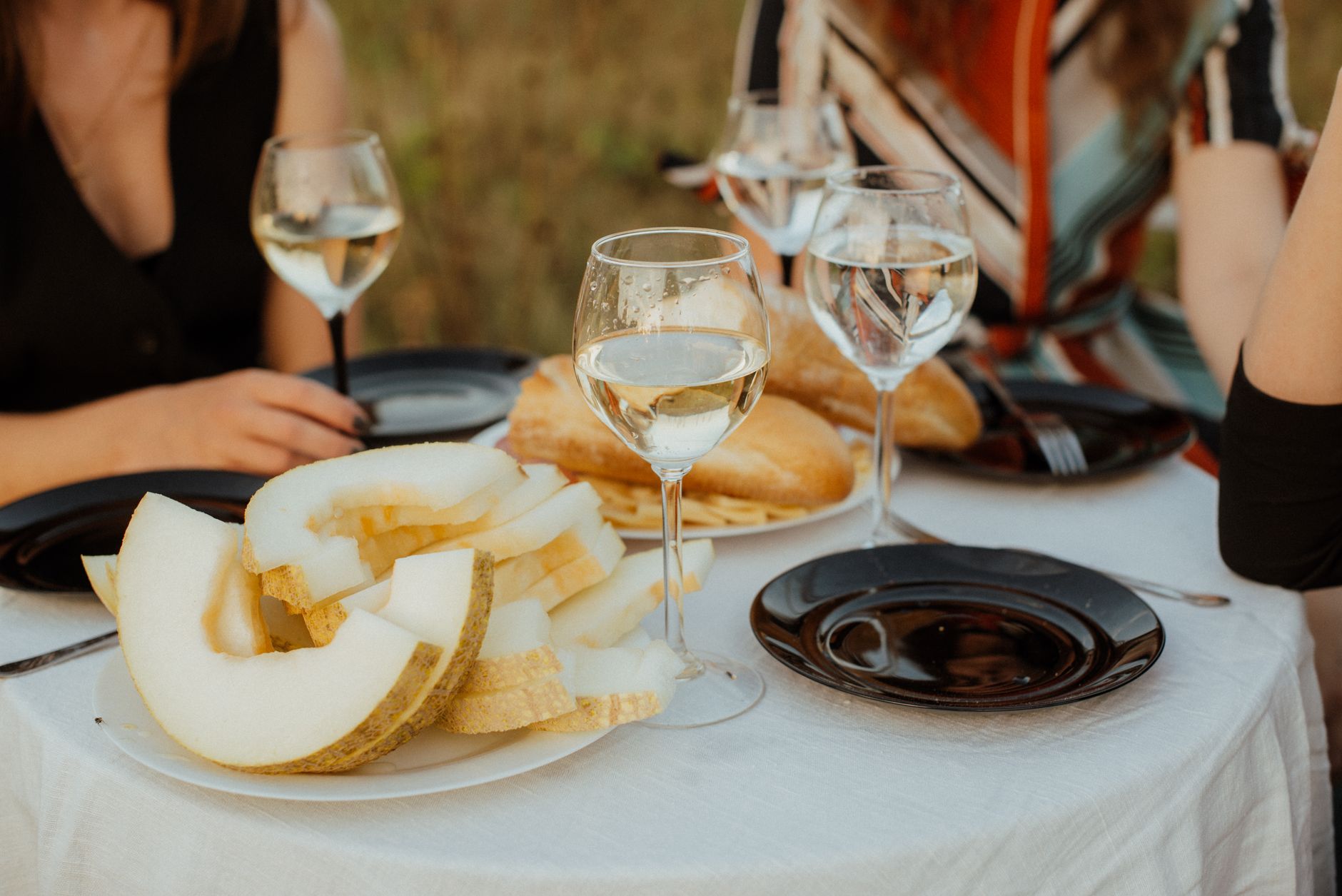 Outdoor food festival stall with glasses of red wine and a chef plating a dish