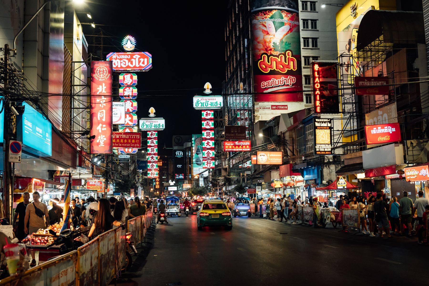 Neon signs and street food stalls along Yaowarat Road in Bangkok's Chinatown at night