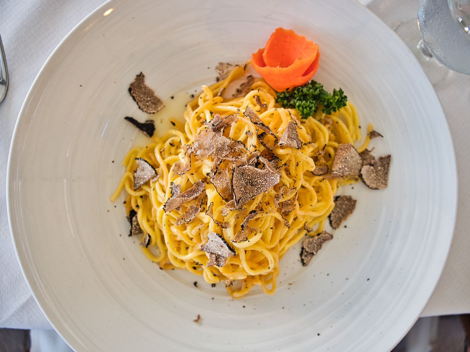 Fresh white truffle shaved generously over a plate of tagliolini pasta