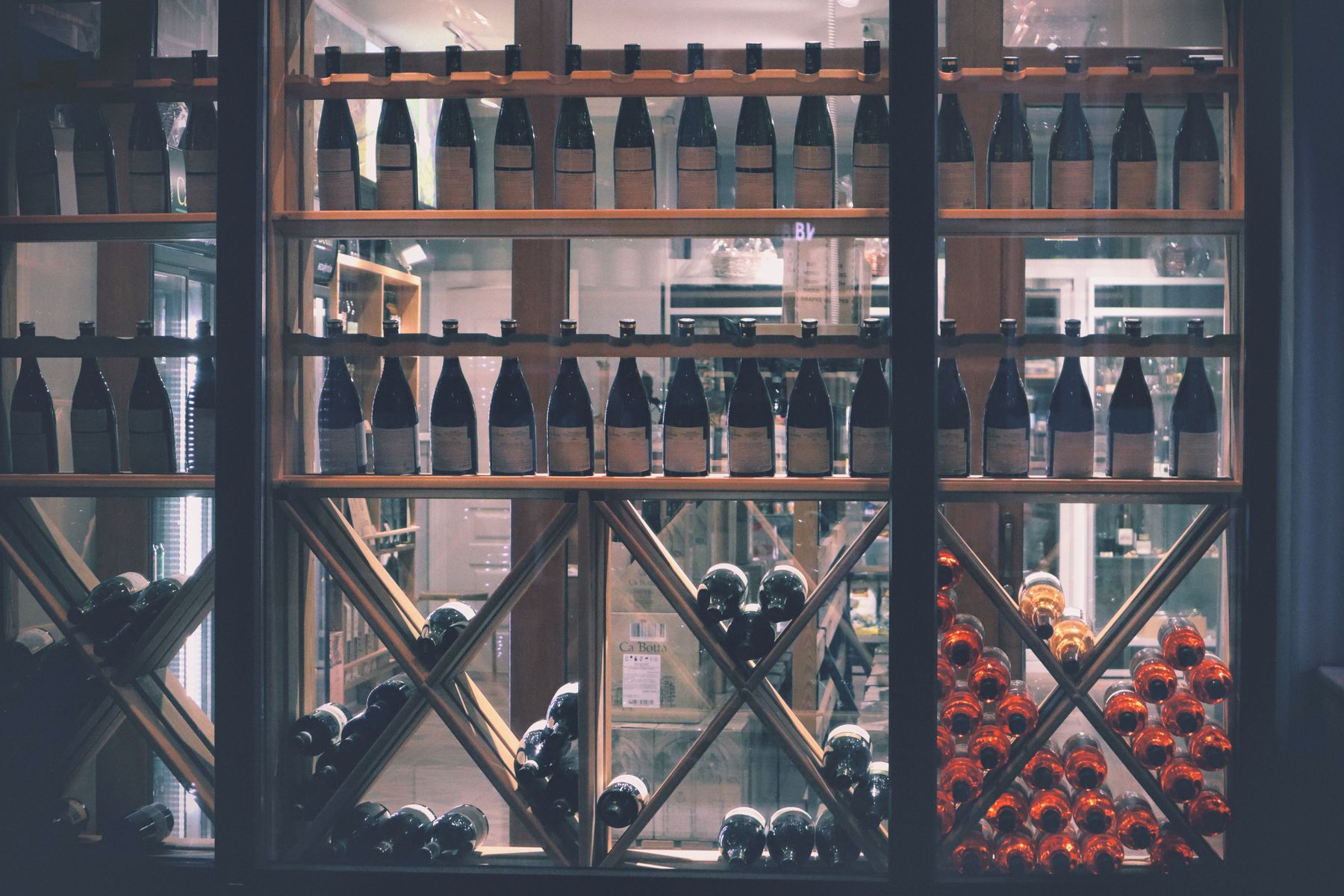 Wine bottles lined up on wooden shelves inside a retail store