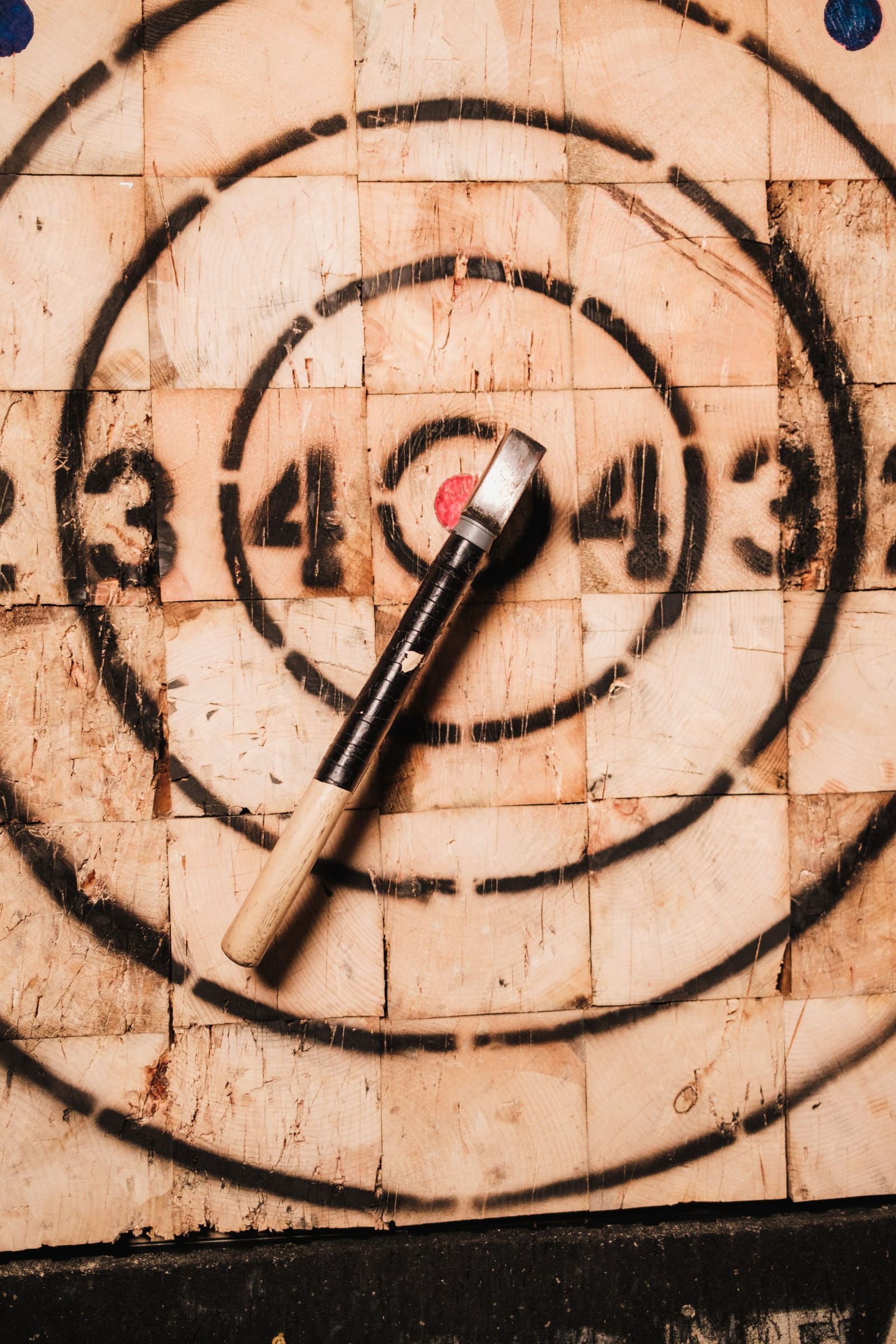 A throwing axe embedded in the bullseye of a wooden target board