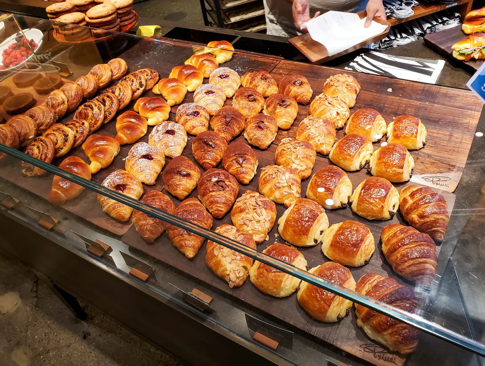 Rangées de croissants et de viennoiseries fourrées sur un comptoir de boulangerie