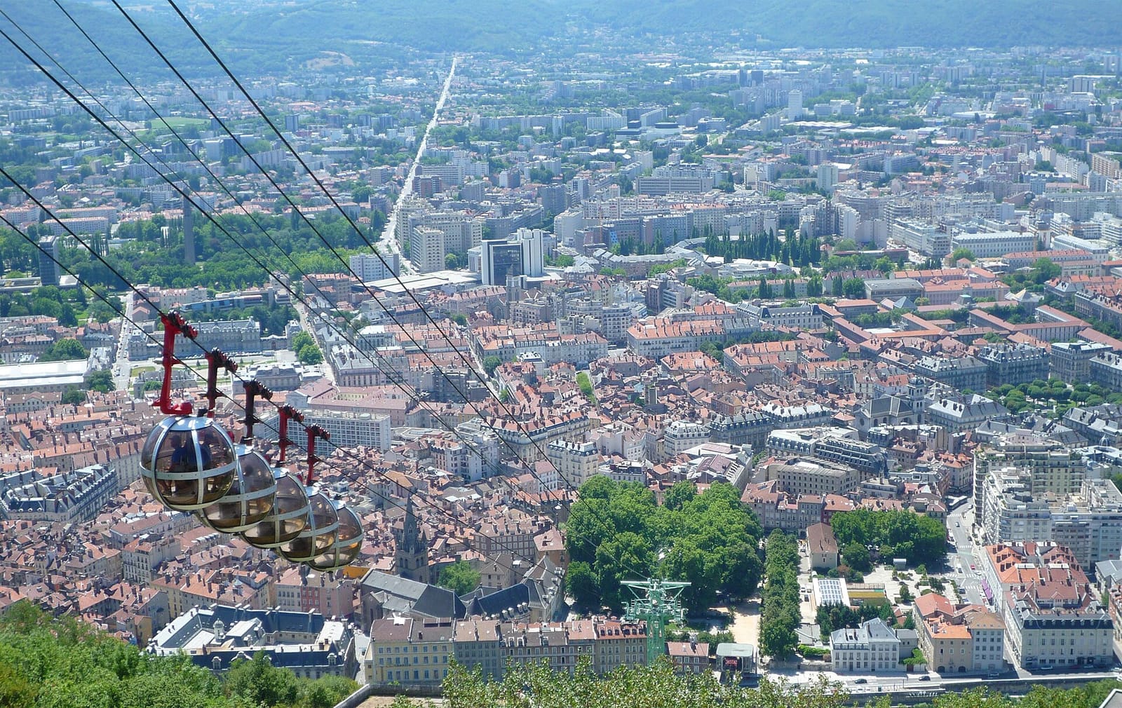 Grenoble van bovenaf gezien, met de bolvormige cabines van de Bastille-kabelbaan boven de daken