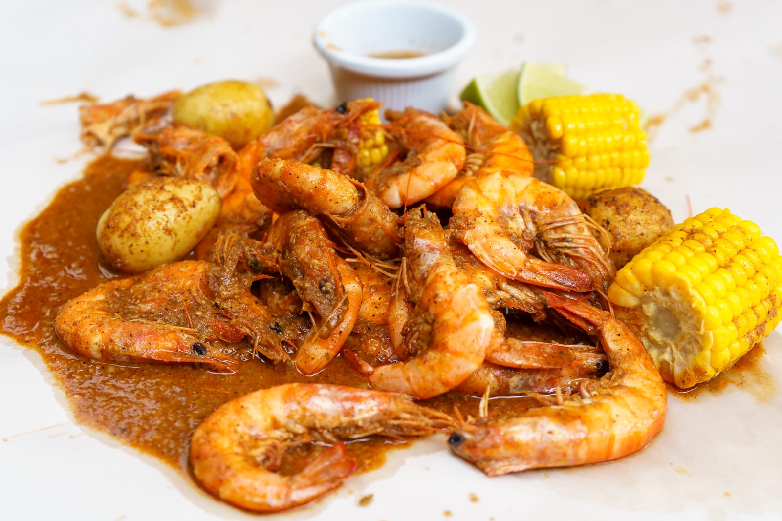 Un piatto di gamberi speziati in stile cajun con mais e patate