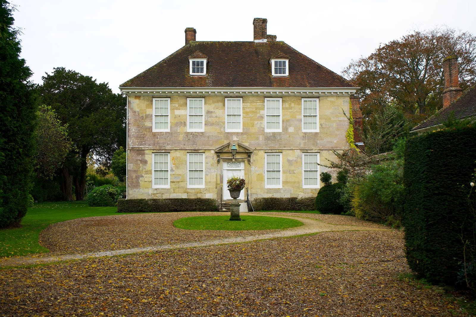 Casa señorial inglesa clásica con camino de grava y jardines