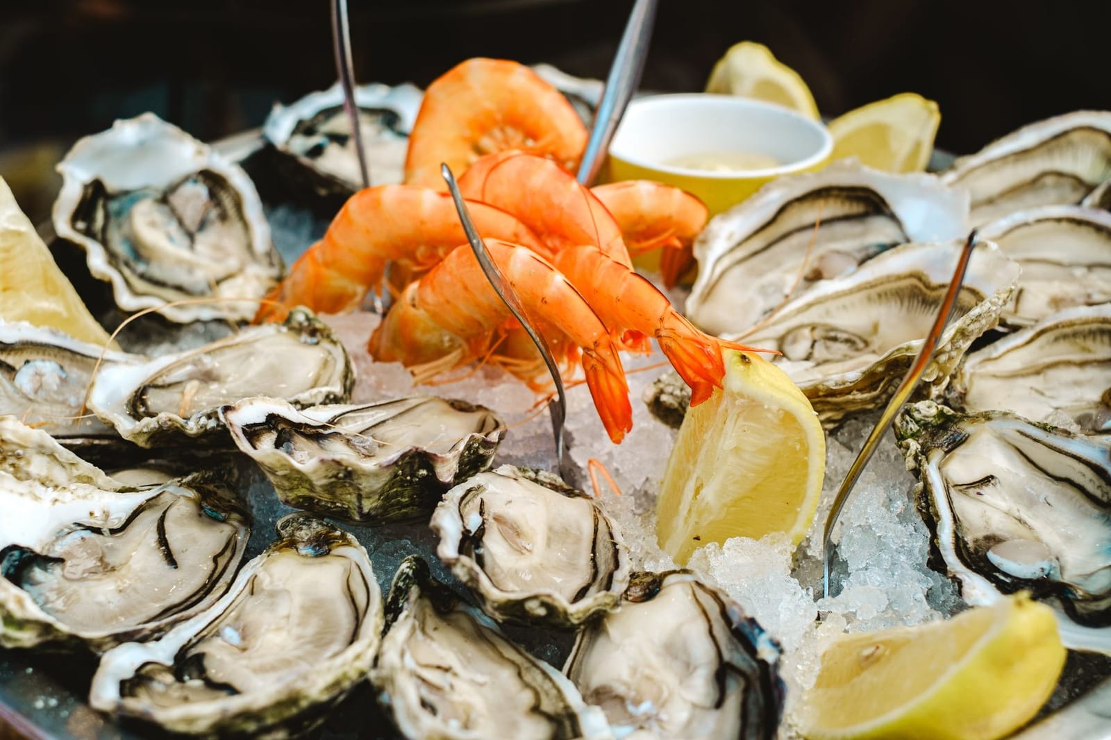 Vers geopende oesters en gekoelde garnalen op ijs met citroen