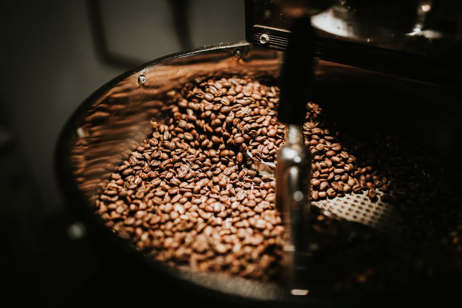Nahaufnahme eines Haufens ganzer gerösteter Kaffeebohnen im warmen Licht