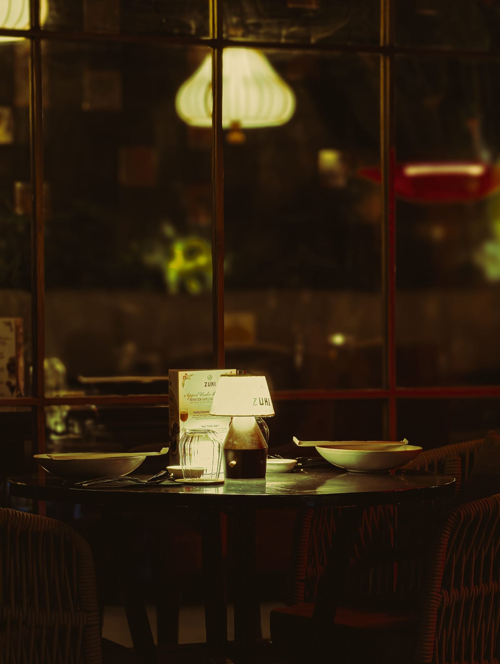 Ein stimmungsvoll gedeckter Restauranttisch, nachts von einer kleinen Lampe beleuchtet
