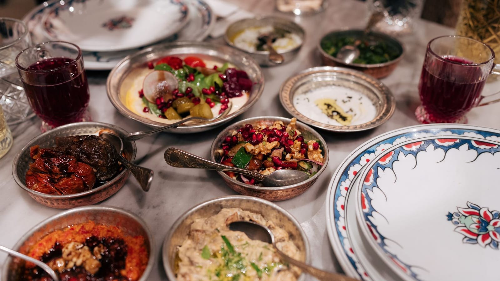 Small copper dishes of mezze, dips and salads spread across a table