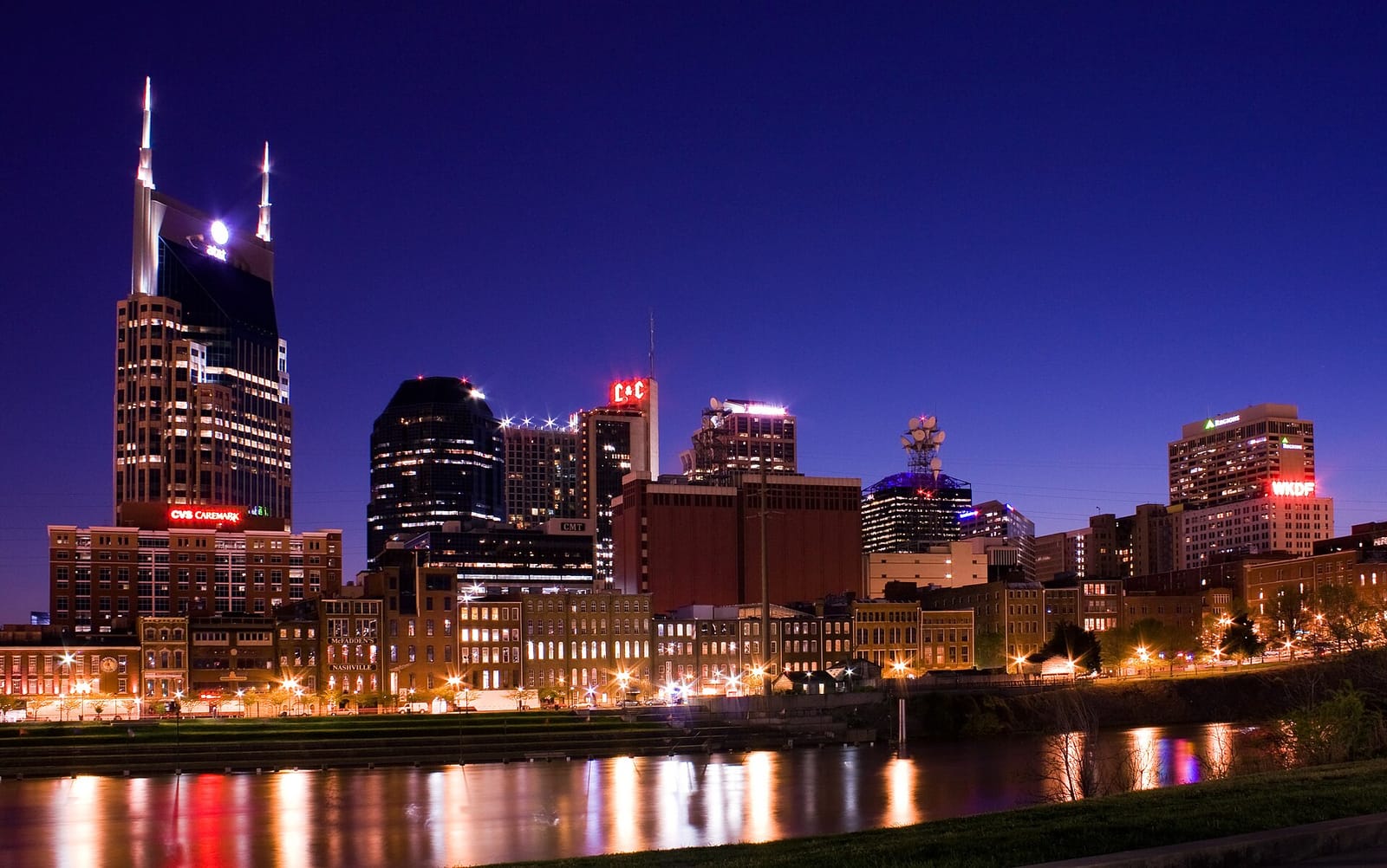 Downtown Nashville skyline lit up at dusk above the Cumberland River