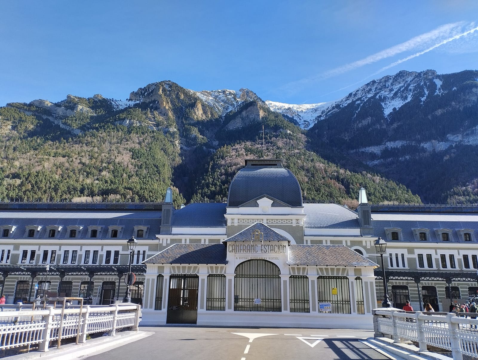 The restored Canfranc international railway station, now a hotel, below snow-capped Pyrenean peaks
