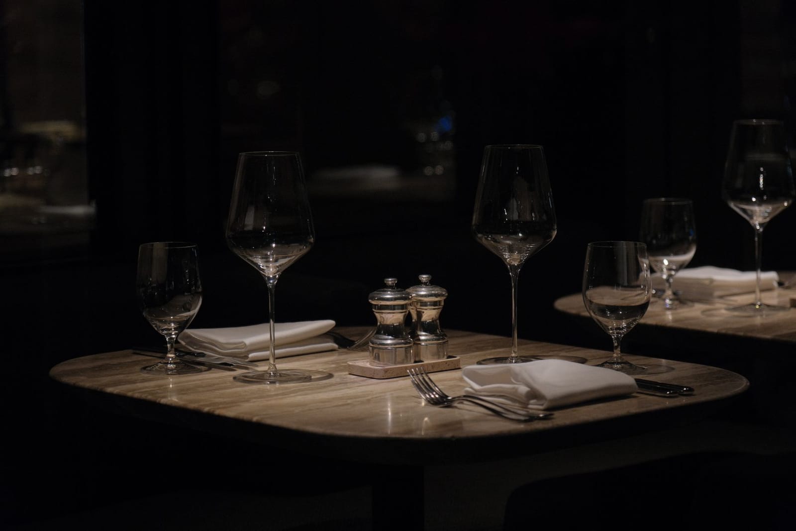 Candlelit table set with wine glasses and folded napkins in a New York dining room