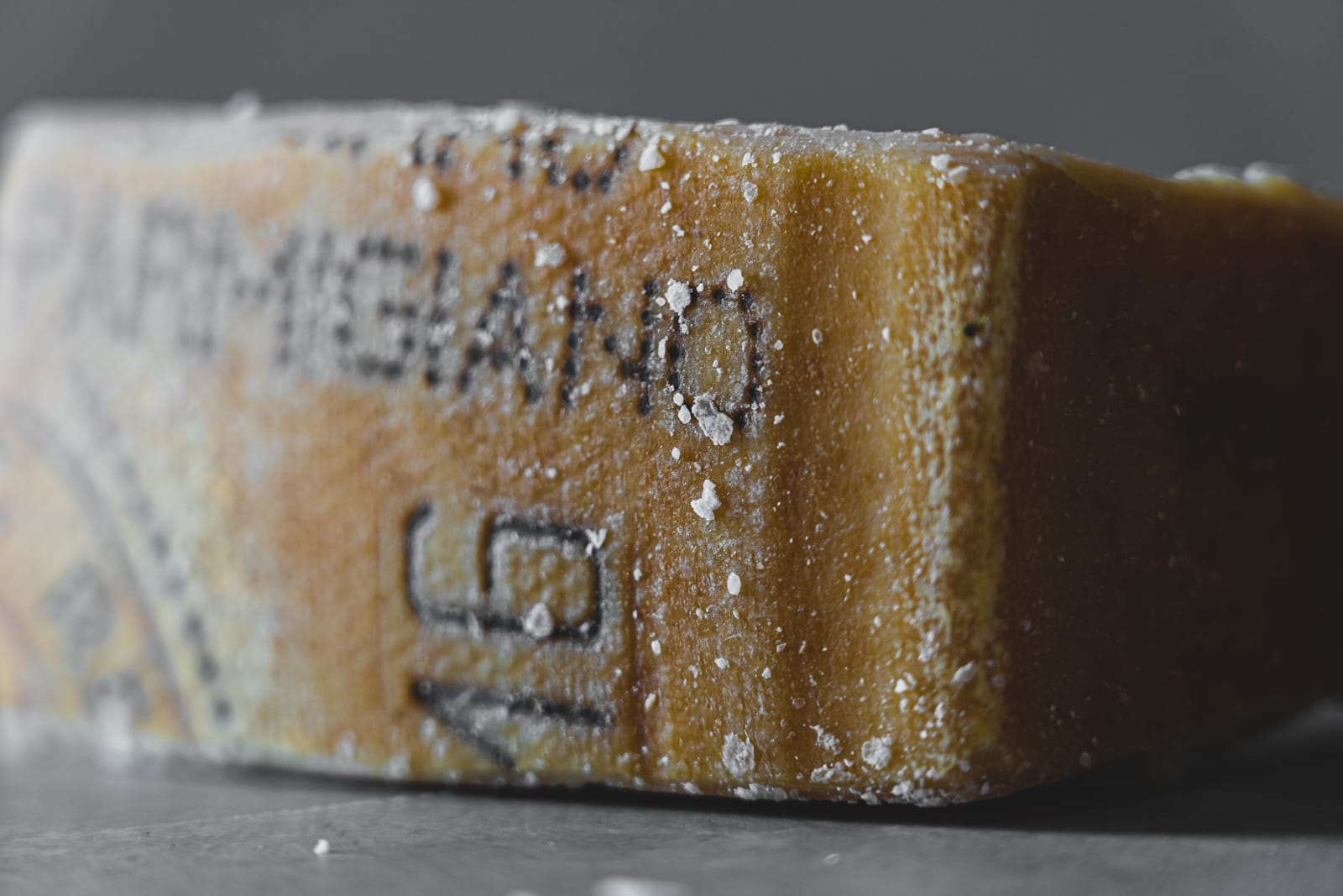 Wheels of Parmigiano Reggiano cheese stacked and ageing in an Italian dairy warehouse