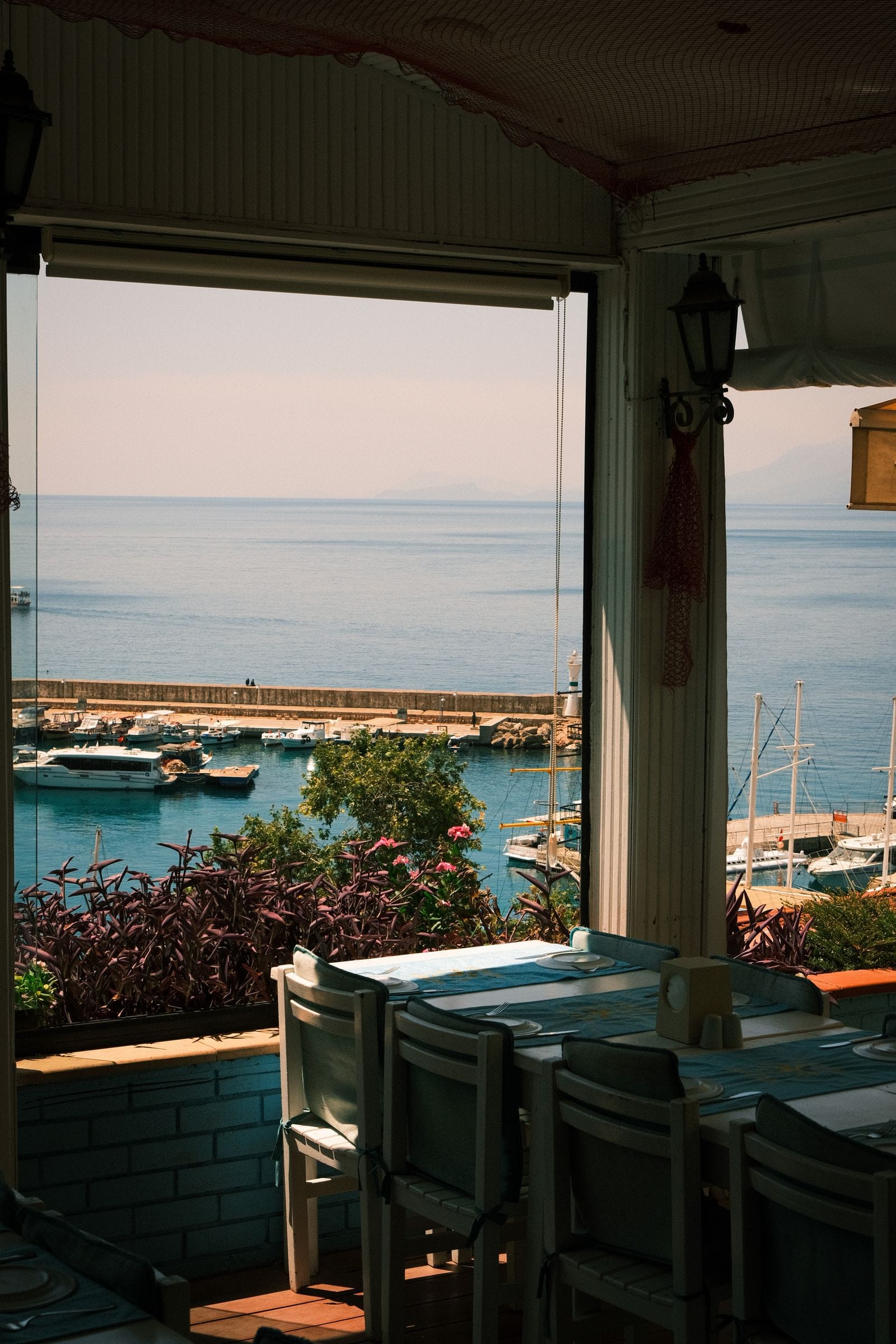 Waterside restaurant terrace with sea view and moored boats