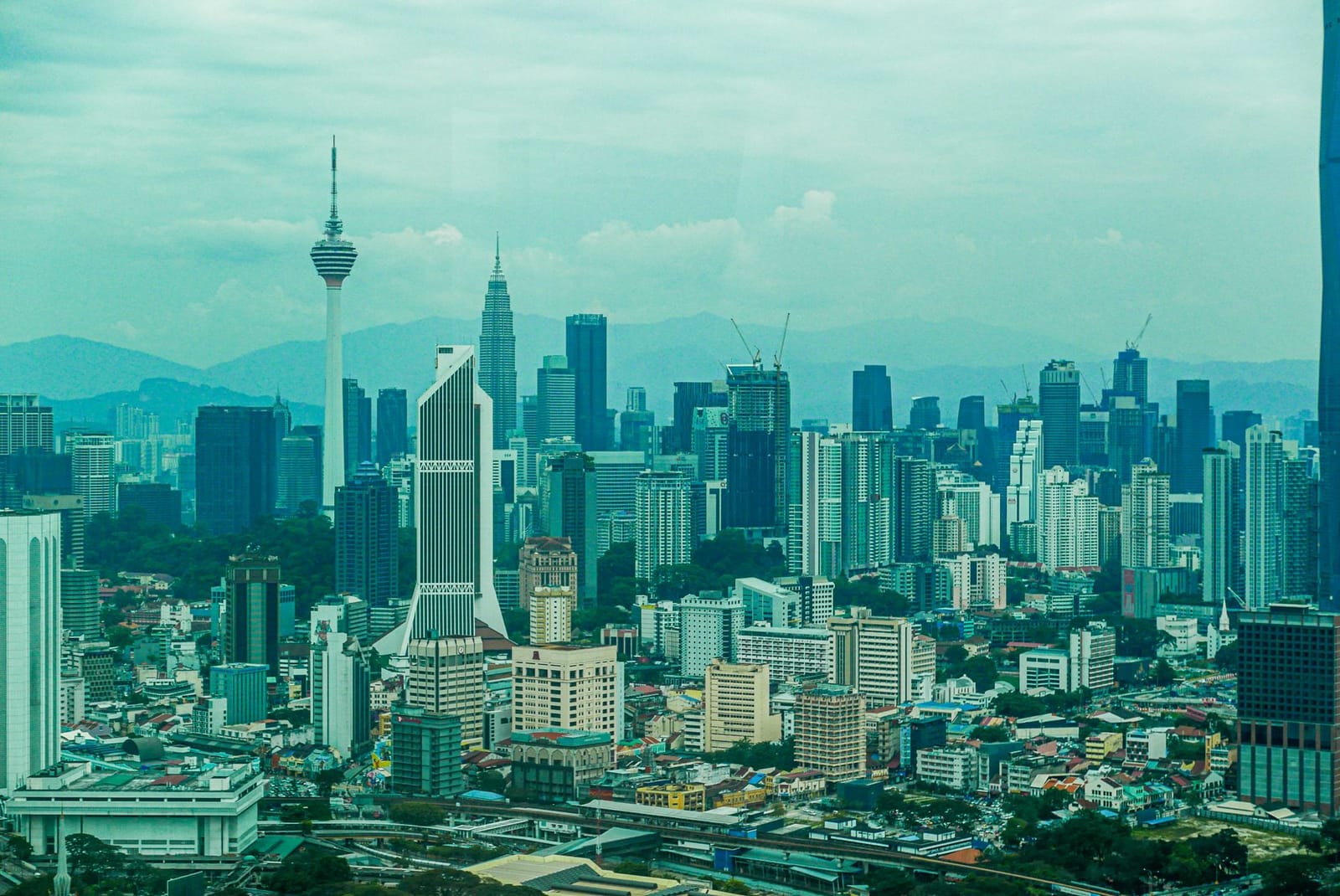 Horizonte de Kuala Lumpur al atardecer con la Torre KL y las Torres Petronas sobre el casco antiguo